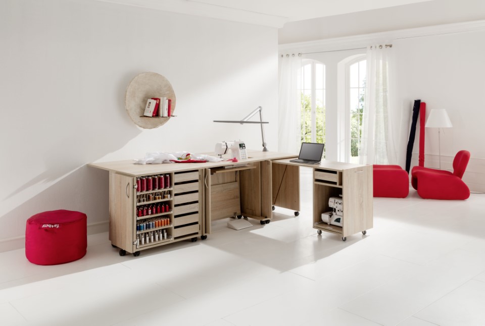 A well-lit room with complete set of sewing materials and furniture